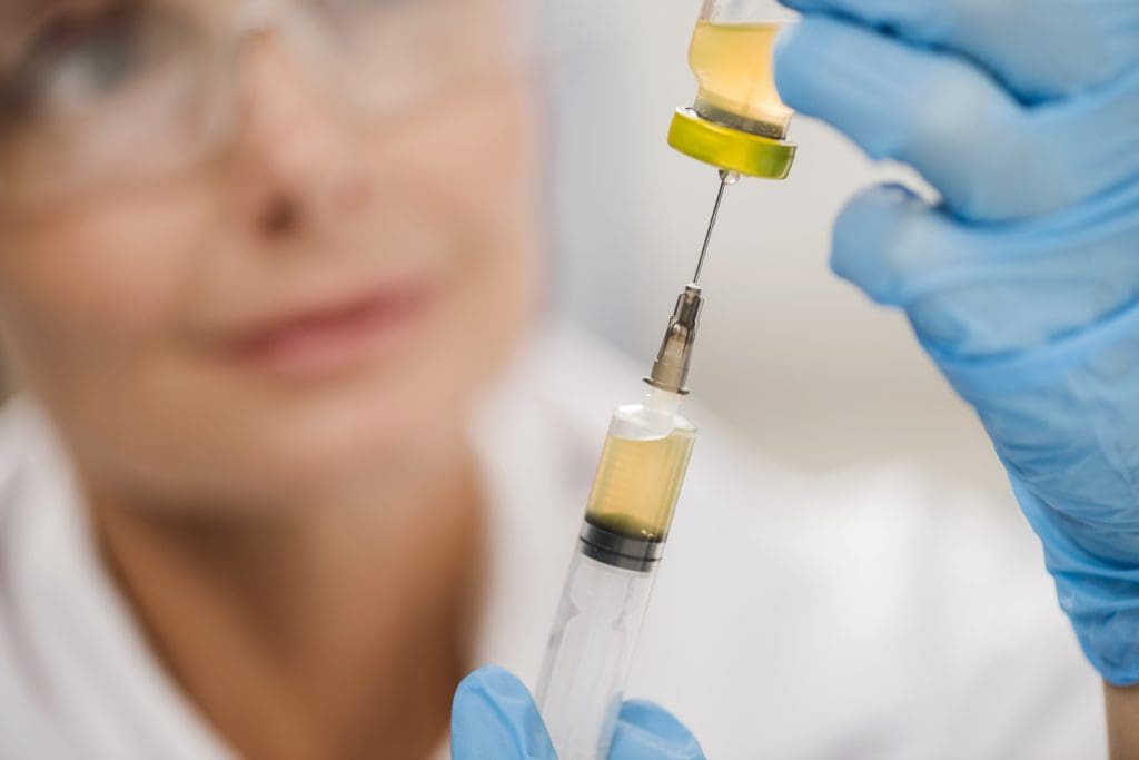high angle defocused female scientist using syringe LIV Hospital