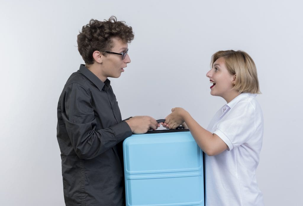 happy young couple tourists man woman holding suitcase looking each other smiling white wall LIV Hospital