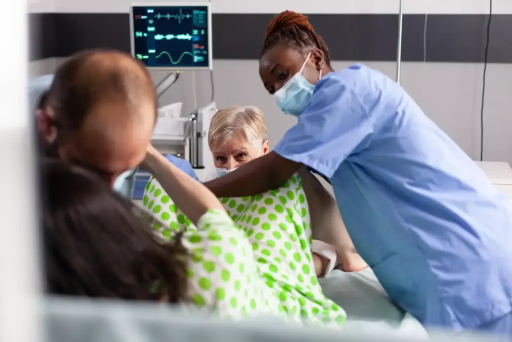 An end-stage glioblastoma multiforme patient lying on a hospital bed, surrounded by medical equipment and family members. A somber, muted palette with dim, warm lighting illuminates the scene. The patient's face is gaunt, eyes closed, and skin pallid, conveying the ravages of the disease. The family members, expressions etched with grief, gather close, their hands intertwined with the patient's. The background is hazy, with medical supplies and monitors fading into the distance, emphasizing the intimacy of the moment. The composition is balanced, with the patient in the center, drawing the viewer's focus to the impending end of life.