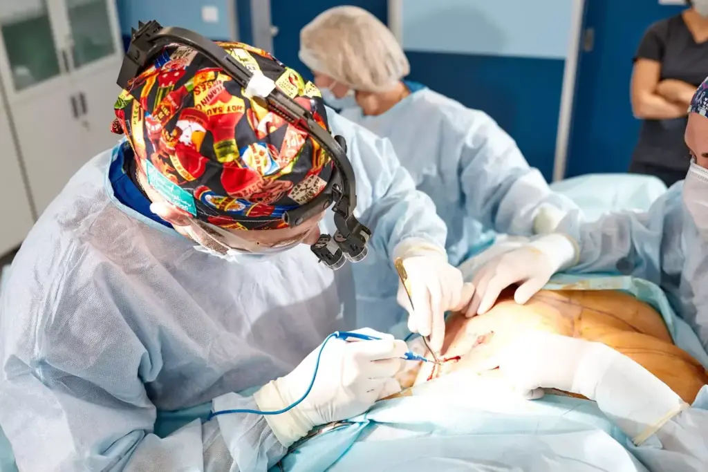 A detailed medical illustration of a myomectomy procedure. The foreground depicts the uterus with visible fibroids being carefully excised by a skilled surgeon using precise surgical instruments. The middle ground shows the surgical team working diligently, wearing sterile gowns and using advanced laparoscopic techniques. The background features the well-lit, modern operating room with state-of-the-art medical equipment. The overall scene conveys a sense of clinical expertise, patient care, and the complexity of the myomectomy procedure. The lighting is bright and natural, capturing the intricate details of the anatomy and surgical instruments. The camera angle provides a clear, informative view of the procedure.