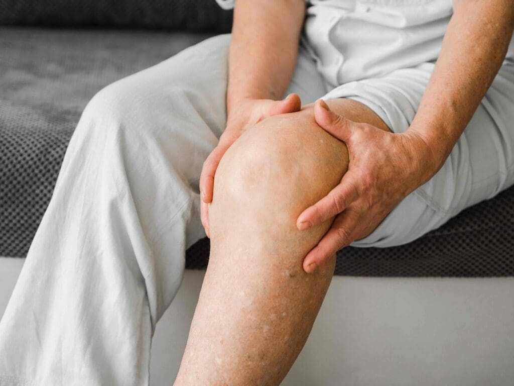 A patient's lower body, focused on the knee area, lit by soft, natural lighting
