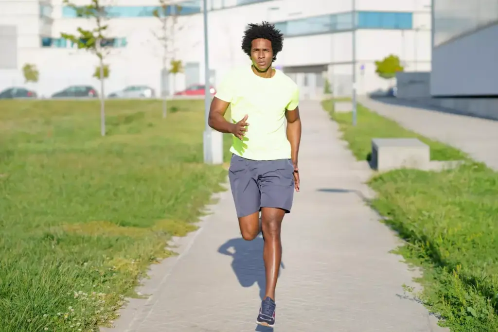 Prompt A person jogging on a paved running track, their knee braced after a recent replacement surgery. They stride with a determined expression, their muscles straining as they push forward. The background is a sun-dappled forest, the trees casting a warm, golden glow. The lighting is soft and natural, creating a sense of tranquility and perseverance. The camera angle is slightly elevated, giving a dynamic perspective on the runner's progress. Overall, the image conveys the steady, gradual recovery process after a major knee procedure, with the runner reclaiming their active lifestyle.