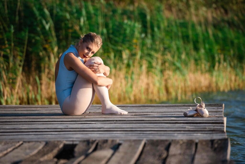 A serene, natural setting with a person sitting on a bench, gently massaging their knee