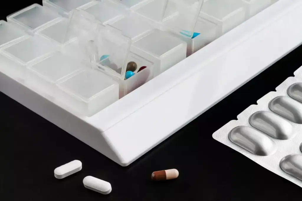 A well-stocked medicine cabinet with an array of over-the-counter arthritis medications prominently displayed. The foreground features various bottles, tubes, and packages of analgesics, anti-inflammatories, and topical creams. The middle ground showcases a clean, well-lit countertop with a few scattered pill packets and a glass of water. The background has a soft, slightly blurred focus, suggesting a calming, domestic environment. The lighting is warm and natural, casting subtle shadows and highlights that emphasize the texture and branding of the products. The overall mood is one of understanding, accessibility, and the promise of pain relief.
