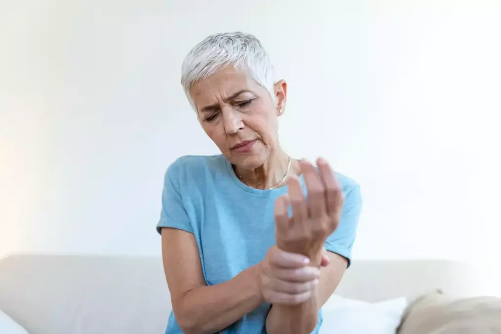 A person experiencing debilitating arthritis pain, gripping their aching hand in a dimly lit room. The foreground features the close-up of the afflicted hand, with prominent, swollen knuckles and wrinkled skin. The middle ground showcases the person's pained expression, their face partially obscured in shadow, conveying a sense of discomfort and frustration. The background is hazy, with a soft, warm glow emanating from a nearby lamp, creating a pensive, introspective atmosphere. The lighting is subdued, casting dramatic shadows that emphasize the severity of the condition, while the lens is focused on the hand, drawing the viewer's attention to the source of the pain. A person experiencing debilitating arthritis pain, gripping their aching hand in a dimly lit room. The foreground features the close-up of the afflicted hand, with prominent, swollen knuckles and wrinkled skin. The middle ground showcases the person's pained expression, their face partially obscured in shadow, conveying a sense of discomfort and frustration. The background is hazy, with a soft, warm glow emanating from a nearby lamp, creating a pensive, introspective atmosphere. The lighting is subdued, casting dramatic shadows that emphasize the severity of the condition, while the lens is focused on the hand, drawing the viewer's attention to the source of the pain.
