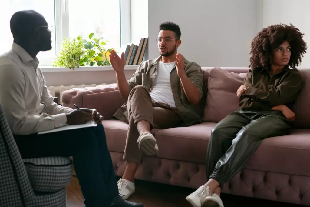 A serene, well-equipped addiction treatment center, bathed in warm, natural lighting. In the foreground, a group of patients engaged in a supportive group therapy session, their faces reflecting hope and determination. The middle ground features a modern, clean-lined interior design, with soothing earth-toned furnishings and artwork promoting mindfulness and self-care. The background showcases an expansive, tranquil outdoor space, with lush greenery and a calming water feature, encouraging patients to find solace in nature during their recovery journey. The overall atmosphere conveys a sense of safety, empowerment, and the belief that addiction is a treatable condition.