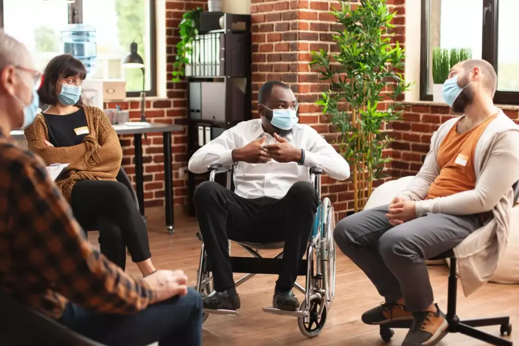 A modern rehabilitation clinic, bathed in soft, warm lighting. In the foreground, a group of patients engaged in a group therapy session, their faces reflecting a sense of hope and determination. The middle ground features a tranquil meditation room, its walls adorned with soothing artwork. In the background, a state-of-the-art gym where patients work to rebuild their physical and mental strength. The overall atmosphere conveys a sense of calm, care, and a focus on holistic treatment, essential for lasting recovery from drug addiction.