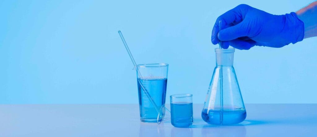 A glass laboratory beaker filled with a vibrant blue liquid, representing chemotherapy drugs for pancreatic cancer treatment A glass laboratory beaker filled with a vibrant blue liquid, representing chemotherapy drugs for pancreatic cancer treatment