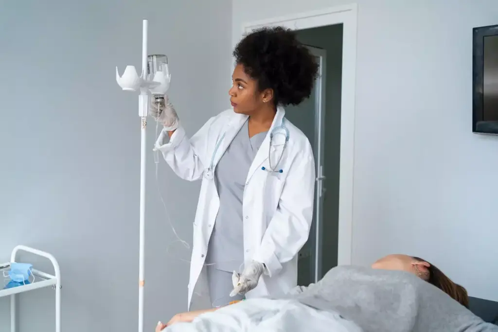 A bright, clinical laboratory setting with modern medical equipment, including an IV stand and infusion bag. In the foreground, a patient reclining comfortably in a treatment chair, their face serene and determined as they undergo chemotherapy. The middle ground features a team of attentive healthcare professionals, their expressions conveying empathy and professionalism. The background showcases state-of-the-art monitoring devices and soothing, natural lighting filtering through large windows, creating a sense of hope and healing. The overall atmosphere is one of quiet resilience, where the patient's well-being is the top priority.
