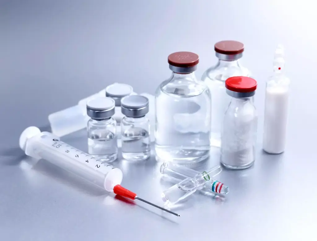 A high-resolution, photorealistic image of four glass vials containing ABVD chemotherapy drugs - adriamycin (doxorubicin), bleomycin, vinblastine, and dacarbazine - arranged on a clean, white laboratory surface. The vials are meticulously detailed, with clearly visible labels and liquid contents. Soft, directional lighting from the left creates subtle shadows and highlights the textural qualities of the glass and liquid. The composition is balanced and centered, with the vials taking up the majority of the frame. The overall mood is clinical, professional, and informative, reflecting the importance of these drugs in Hodgkin lymphoma treatment.