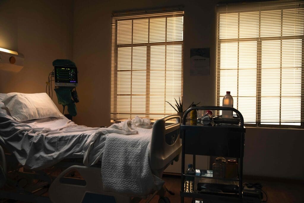 A neatly organized hospital room, bathed in warm, natural lighting that filters through large windows
