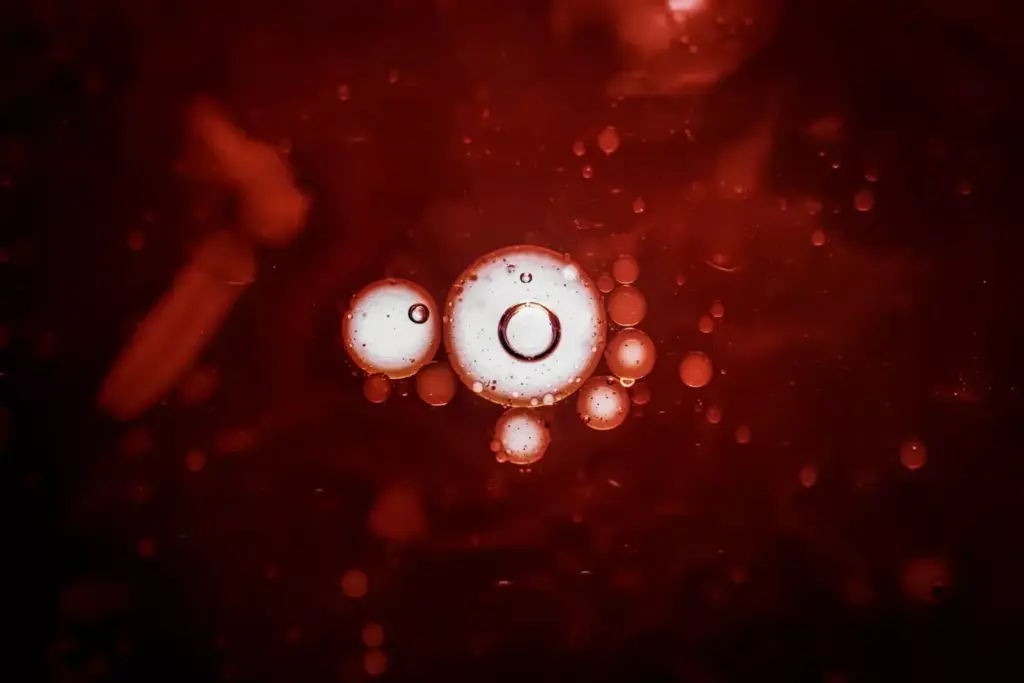 A close-up view of a blood cell under a microscope, illuminated by a warm, soft lighting. In the foreground, a cluster of red blood cells, their intricate shapes and textures visible. In the middle ground, a single white blood cell, its nucleus and cytoplasm clearly defined, surrounded by the vibrant red cells. In the background, a hazy, blurred representation of a chemotherapy drug vial, symbolizing the treatment's impact on the body's cellular composition. The overall mood is one of scientific exploration, with a sense of the delicate balance within the human bloodstream.