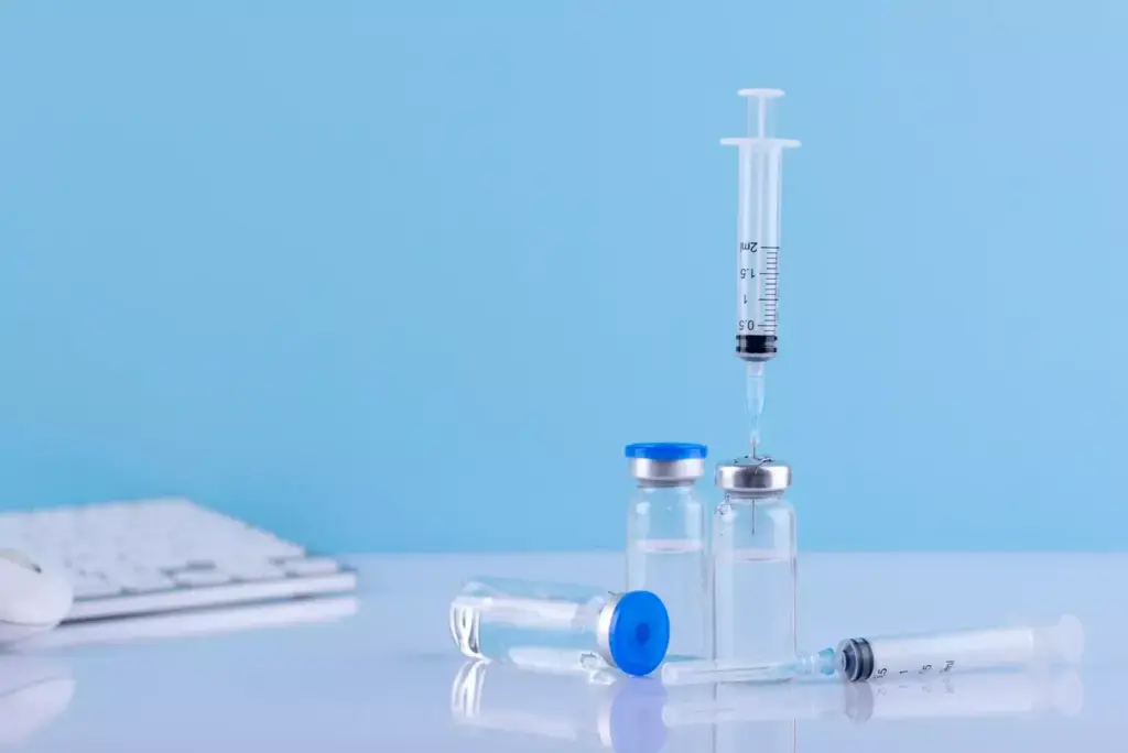 A clinical, well-lit medical setting with a table in the foreground displaying an assortment of chemotherapy needles. The needles are meticulously arranged, showcasing their varying sizes, gauges, and tip designs. The background is blurred, maintaining the focus on the central subject. Soft, directional lighting highlights the metallic sheen of the needles, conveying a sense of precision and professionalism. The overall mood is informative and educational, suitable for a medical reference article.
