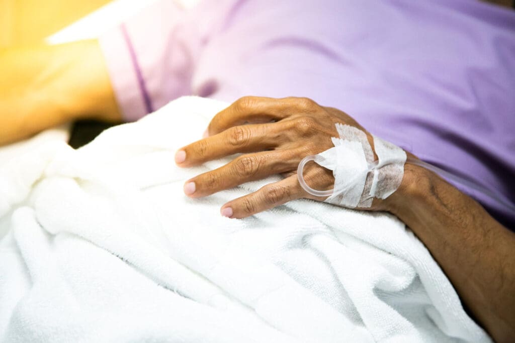 Midsection of patient resting on bed in hospital