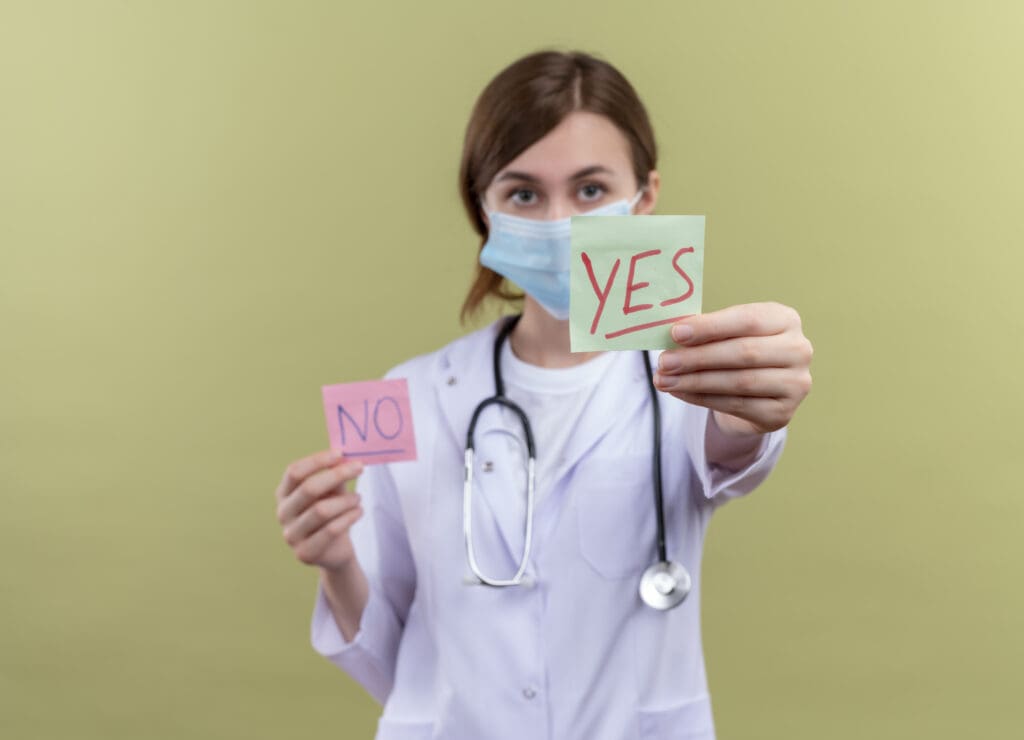 young female doctor wearing medical robe mask stethoscope stretching yes note isolated green wall with copy space LIV Hospital