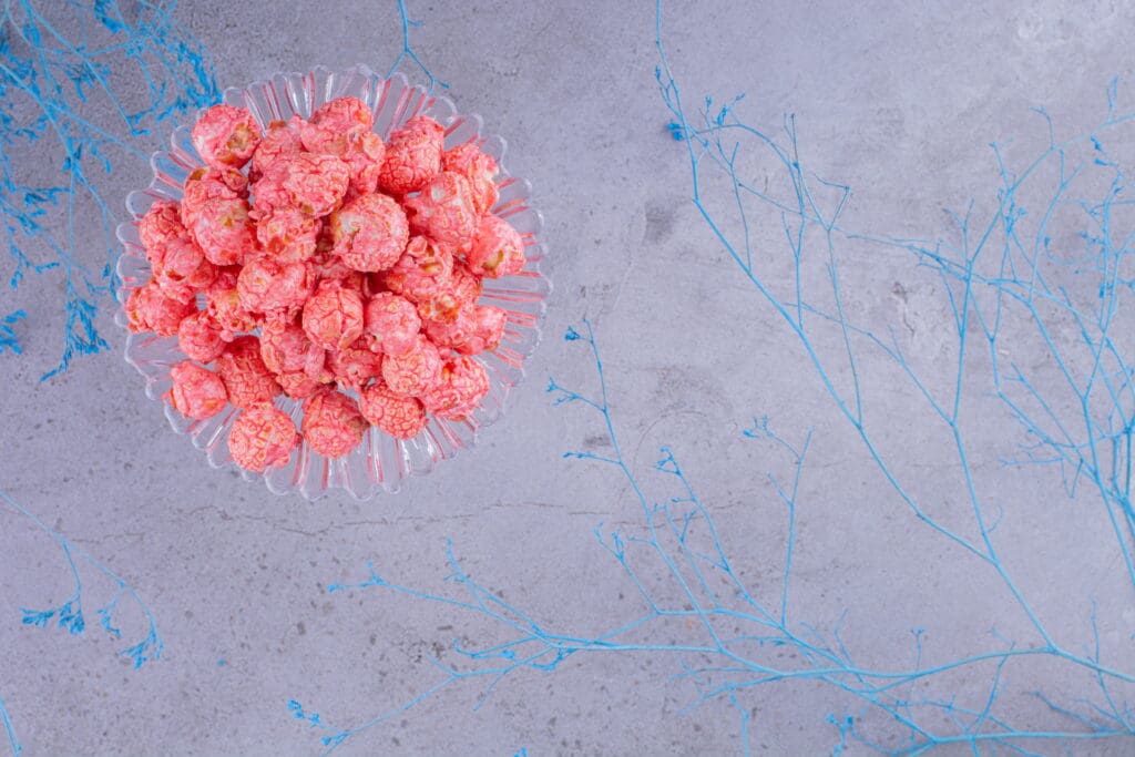 glass holder with portion popcorn candy decorative blue branches marble background high quality photo LIV Hospital