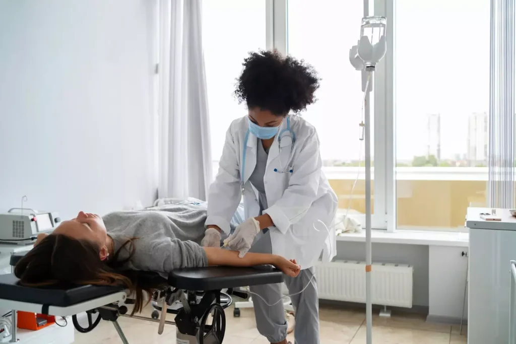 Patient lying on a hospital  bed receiving an IV injection