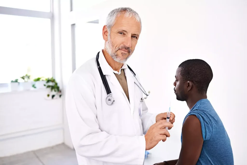 Doctor needle and man in hospital for vaccine healthcare and medicine Doctor needle and man in hospital for vaccine healthcare and medicine