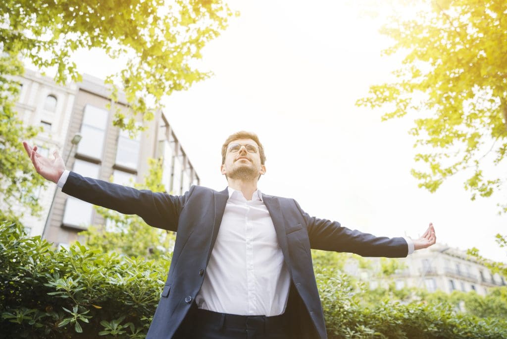 low angle view businessman standing front building outstretching his arms LIV Hospital