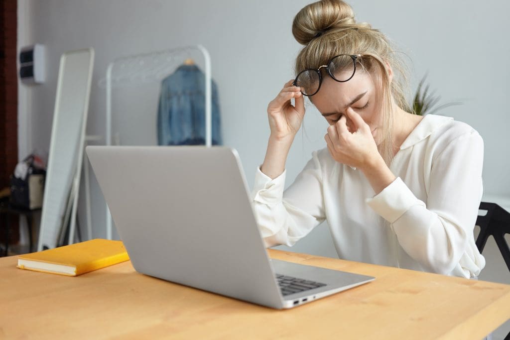 modern technology job people concept portrait tired young female employee with hair bun taking off eyeglasses massaging her nose bridge feeling stressed because lot work LIV Hospital