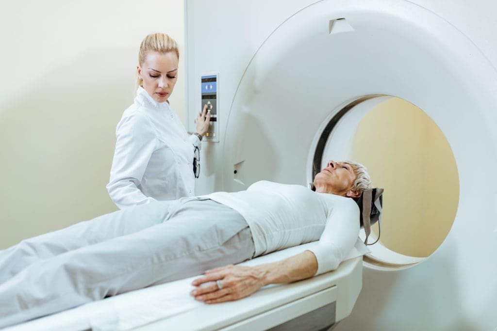 Critical PET Scan Contraindications You Must Know 1 senior woman undergoing mri scanner while doctor is supervising procedure 2 LIV Hospital