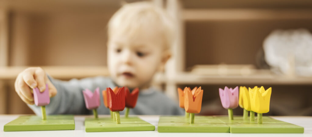 selective focus boy39s hand ordering wooden toy by color 1 LIV Hospital