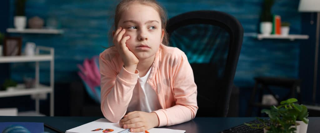 little girl doing homework feeling bored sad 1 LIV Hospital