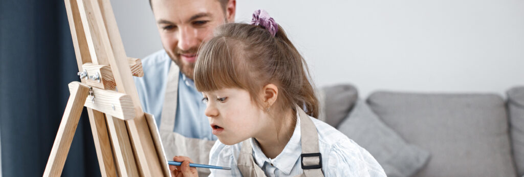 girl with down syndrome her father painting easel with brushes 1 LIV Hospital