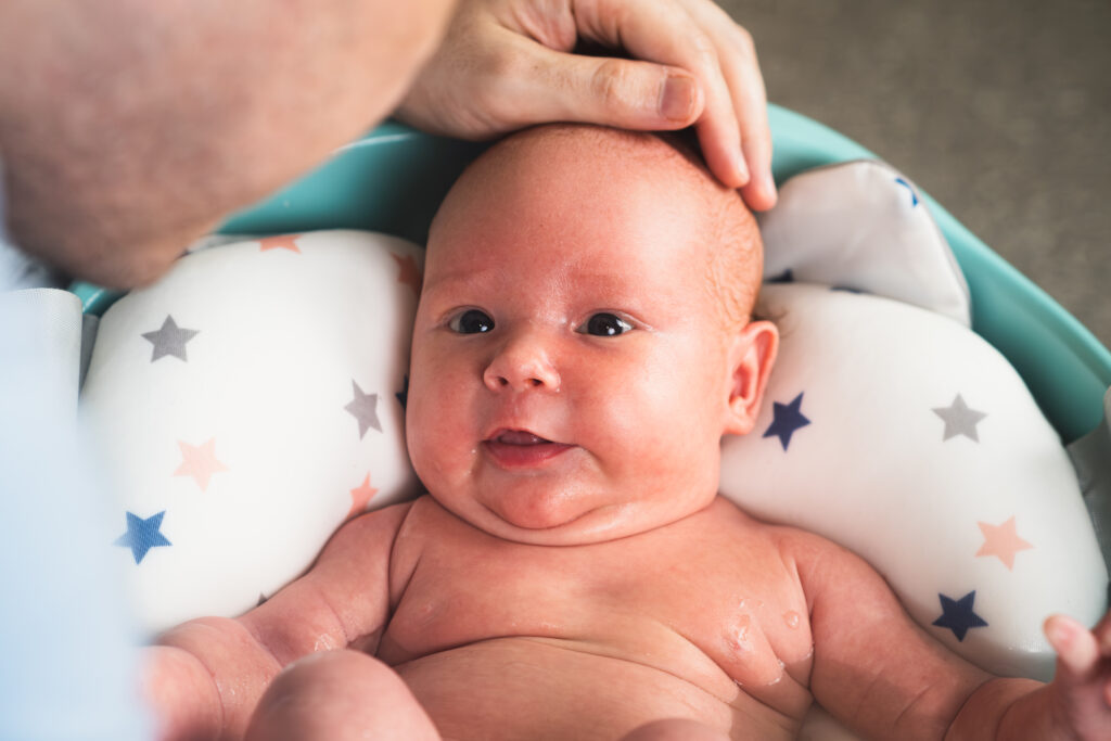 dad bathes his newborn daughter bathing newborn baby bathtub lovely child is undergoing military training first time LIV Hospital