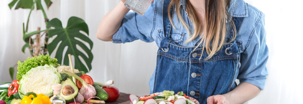 young woman drinks water table with vegetables light background dressed denim clothes healthy food drink concept 1 LIV Hospital
